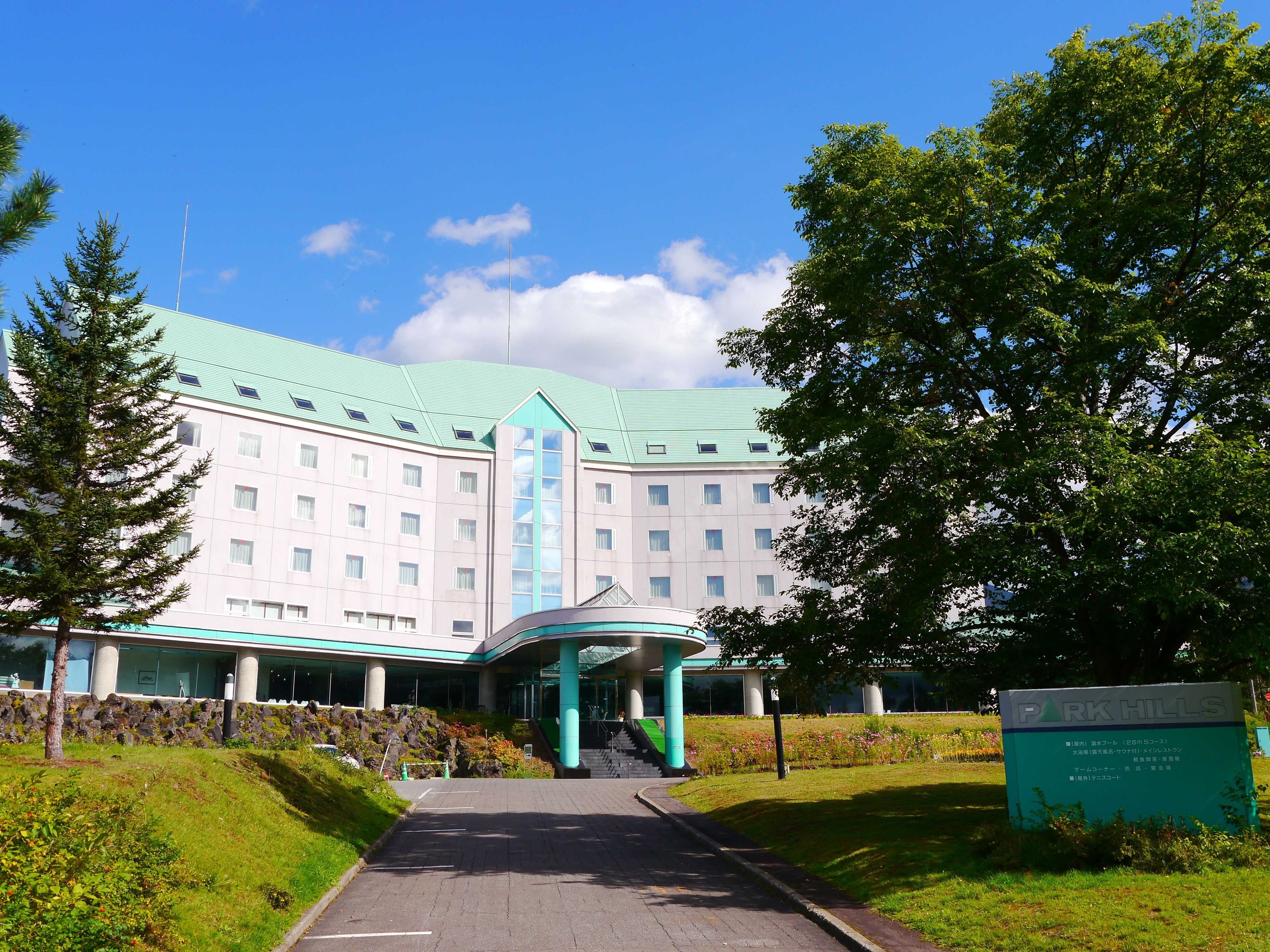 Un grand hôtel doté d’un toit végétalisé et d’une entrée centrale.