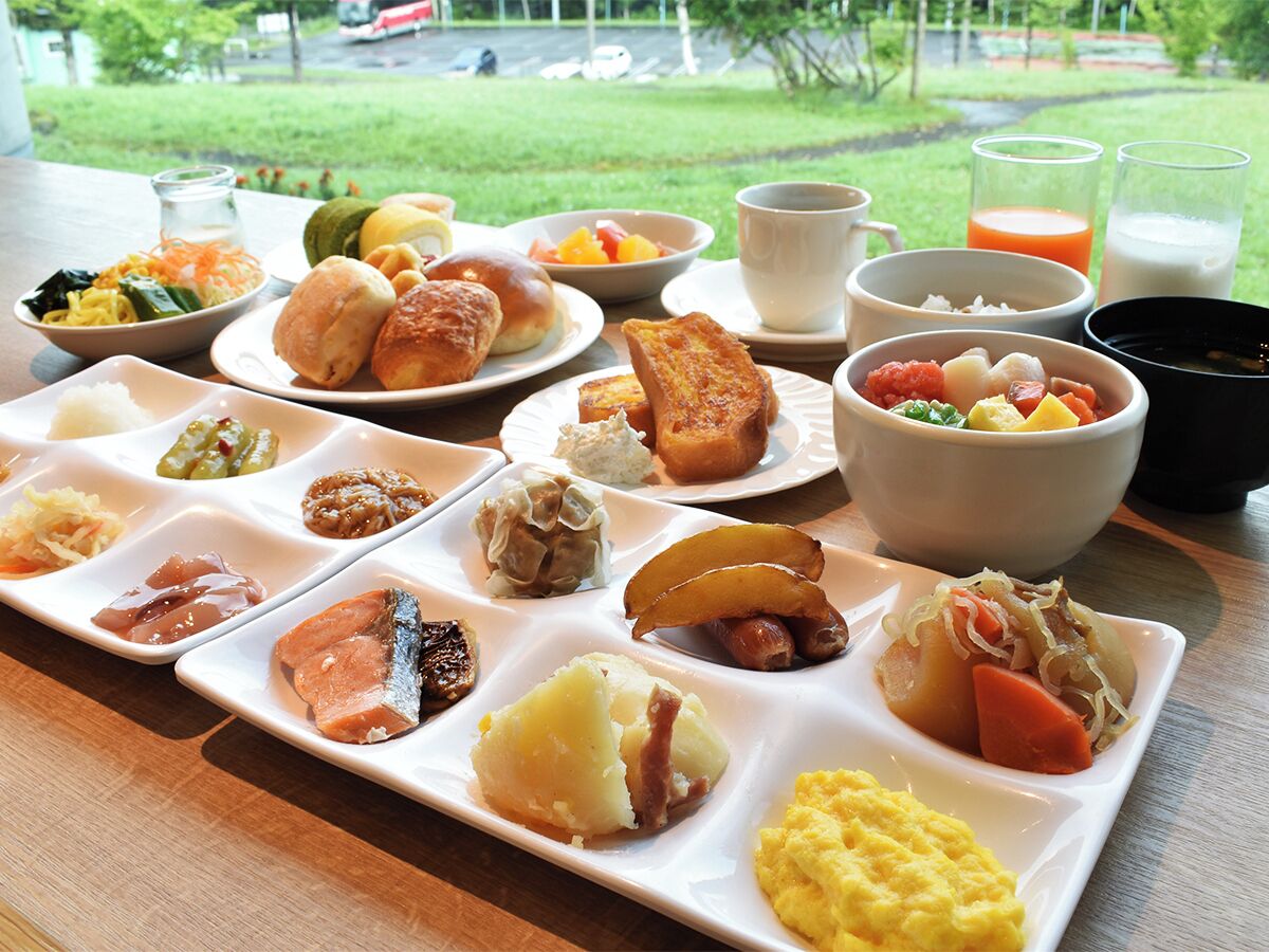 Un bufé de desayuno con diversos platos y bebidas sobre una mesa.