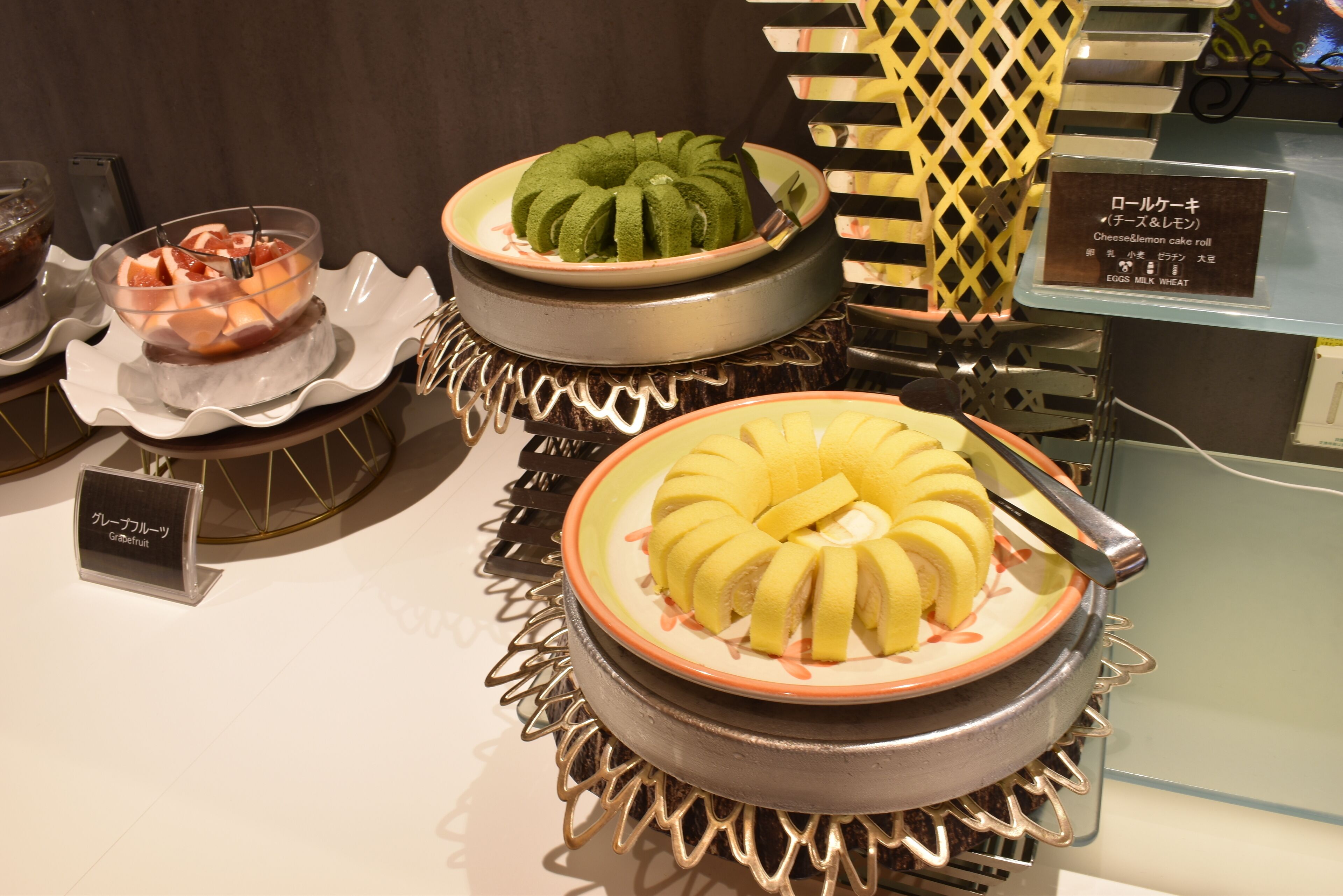A display of various cakes with labels in a restaurant setting.
