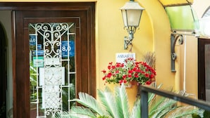Entrada de un hotel con una reja de hierro forjado, un letrero que dice 'Annabelle' y una lámpara fijada a la pared.