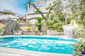 Una piscina al aire libre de temporada, sillones reclinables de piscina