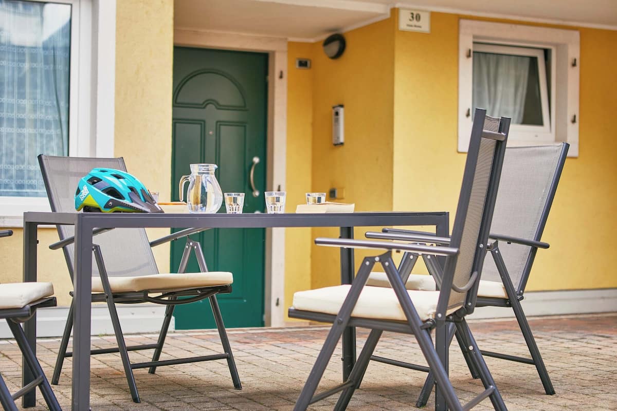 A table with chairs, a helmet, and a pitcher.