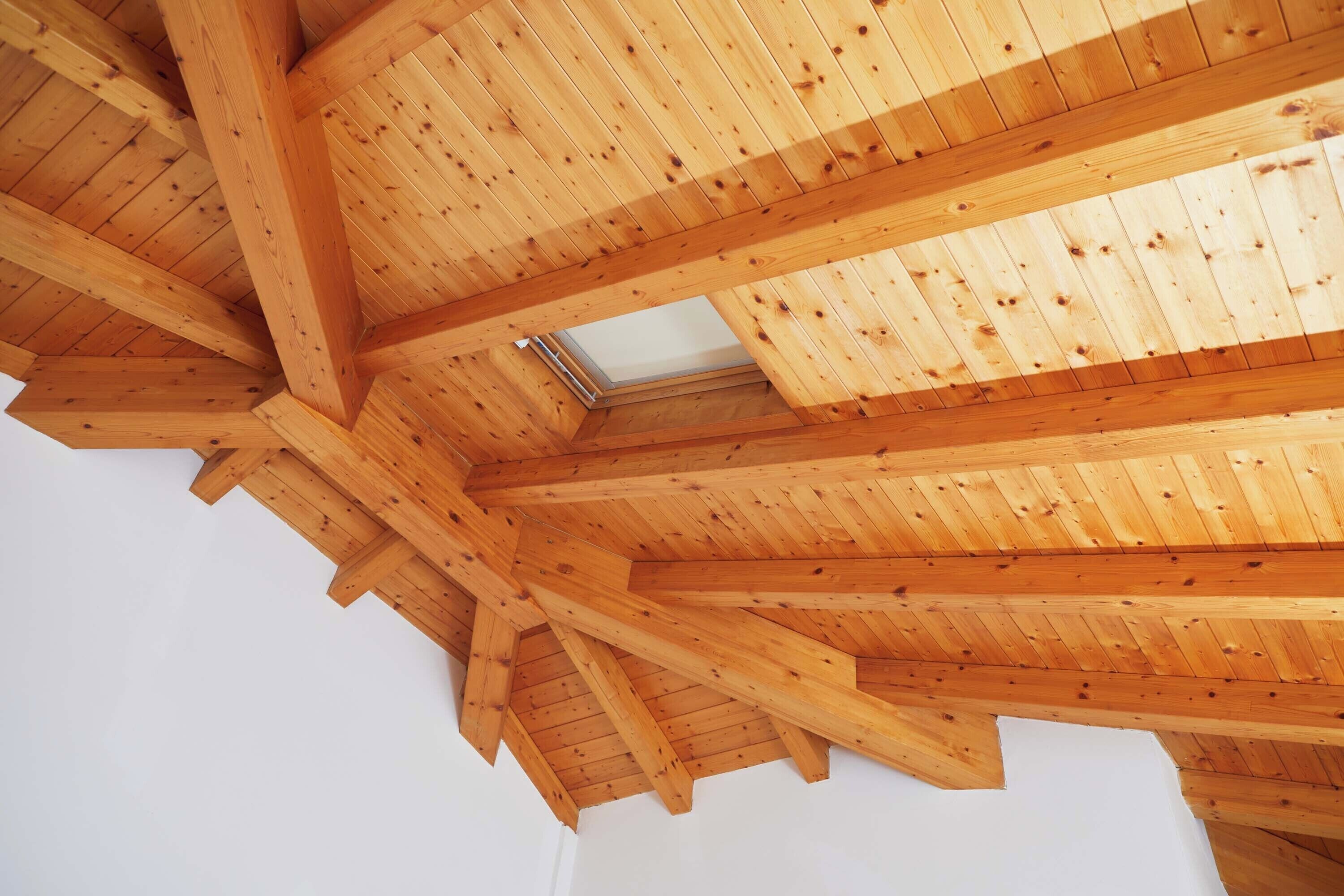 A wooden ceiling with a skylight.