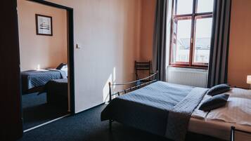 A bedroom with a bed, a chair, a window, and a door.