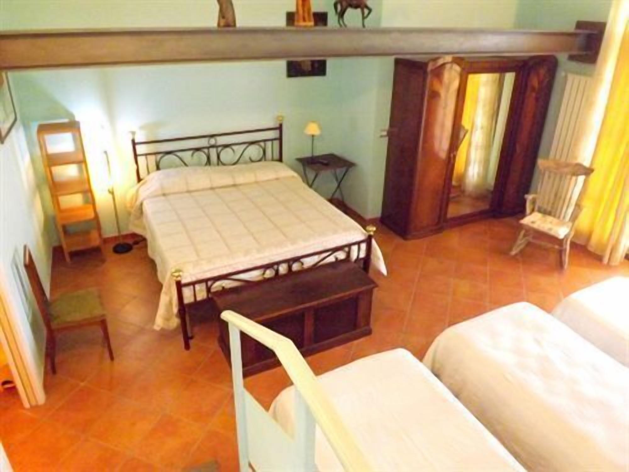 Ein Schlafzimmer mit einem Bett, einem Sessel, einem kleinen Tisch und einer Leiter.