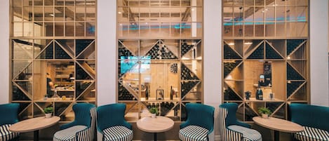 Zona de bar con asientos y estanterías para vinos.