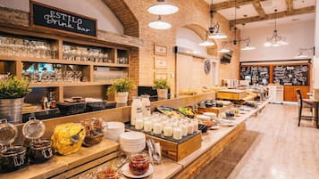 A cafe with a brick wall, wooden beams, and a long counter with various food items and drinks.