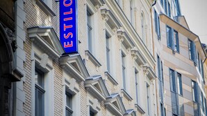 Facciata di un hotel con un cartello blu ben visibile con la scritta "ESTILO HOTEL".