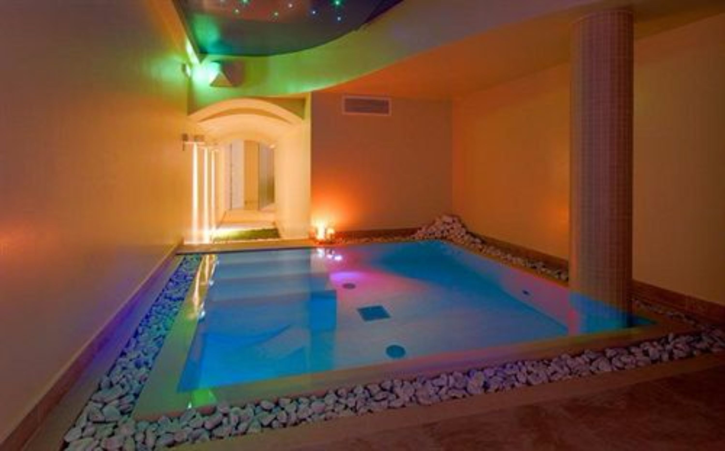 A spa area with a pool, stone-lined edges, and ambient lighting.