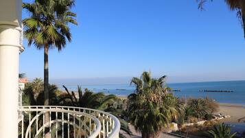 A balcony with a view of the beach and ocean.