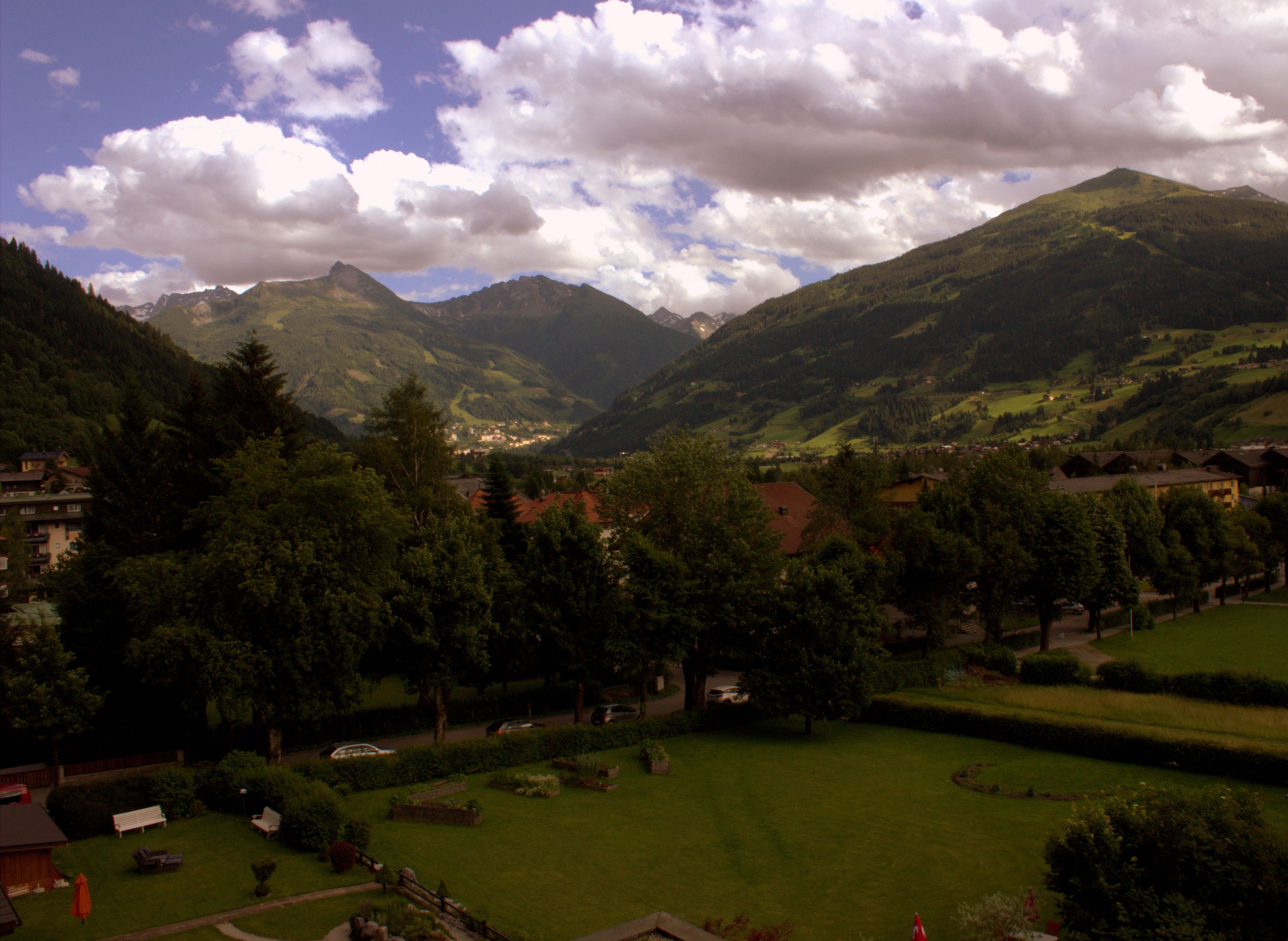Eine gebirgige Landschaft mit einem Tal, Häusern und einem kleinen Dorf.