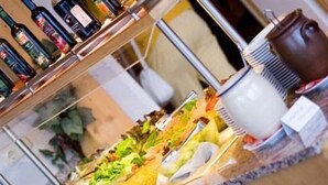 Un buffet proposant divers plats, une machine à café et un assortiment de boissons en bouteille.