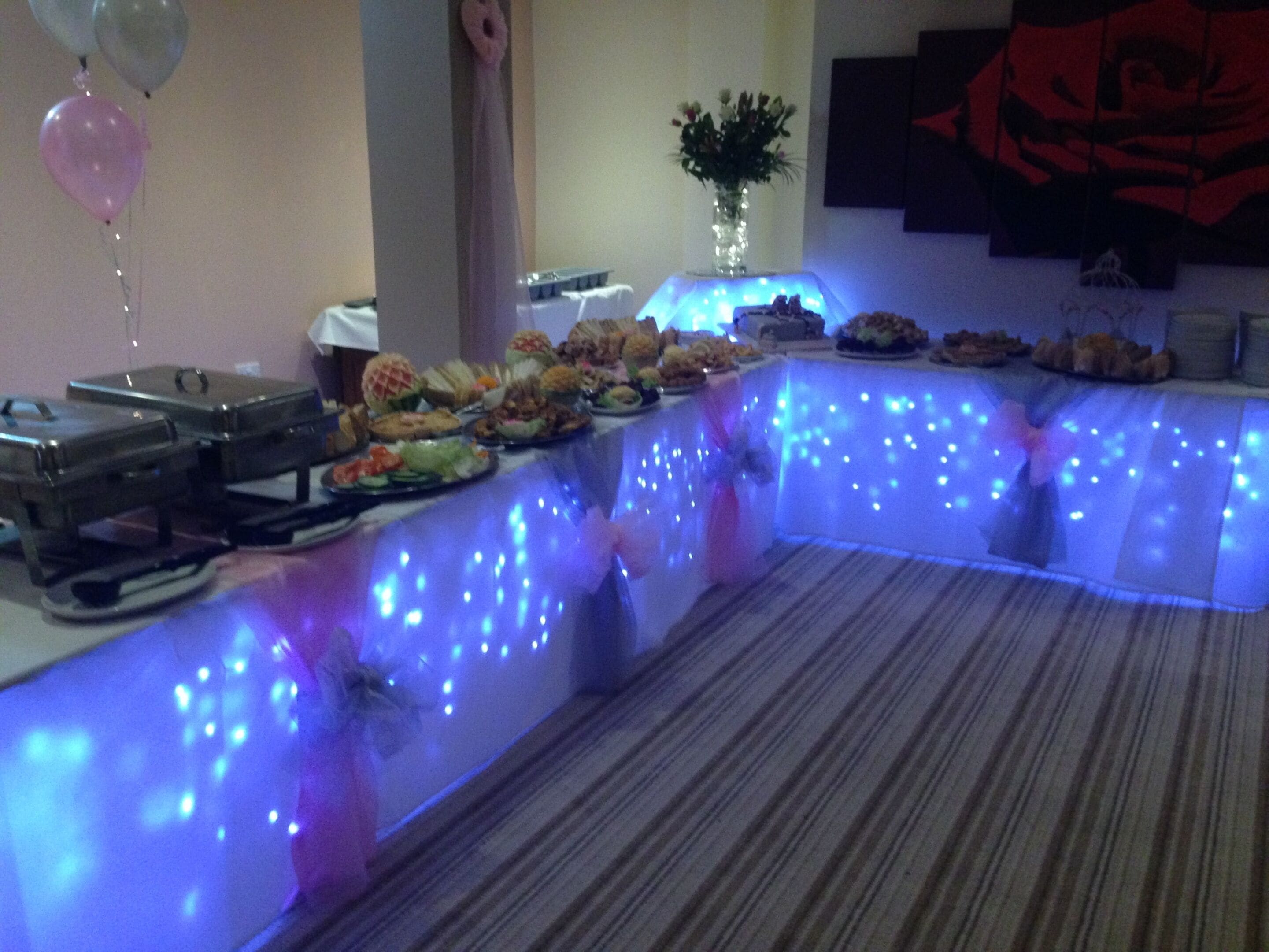 Une table de buffet garnie de divers plats et un vase rempli de fleurs.