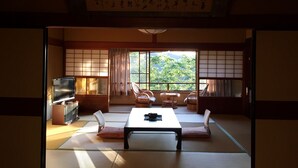 Una habitación japonesa tradicional con suelo de tatami, una mesa baja y puertas correderas.