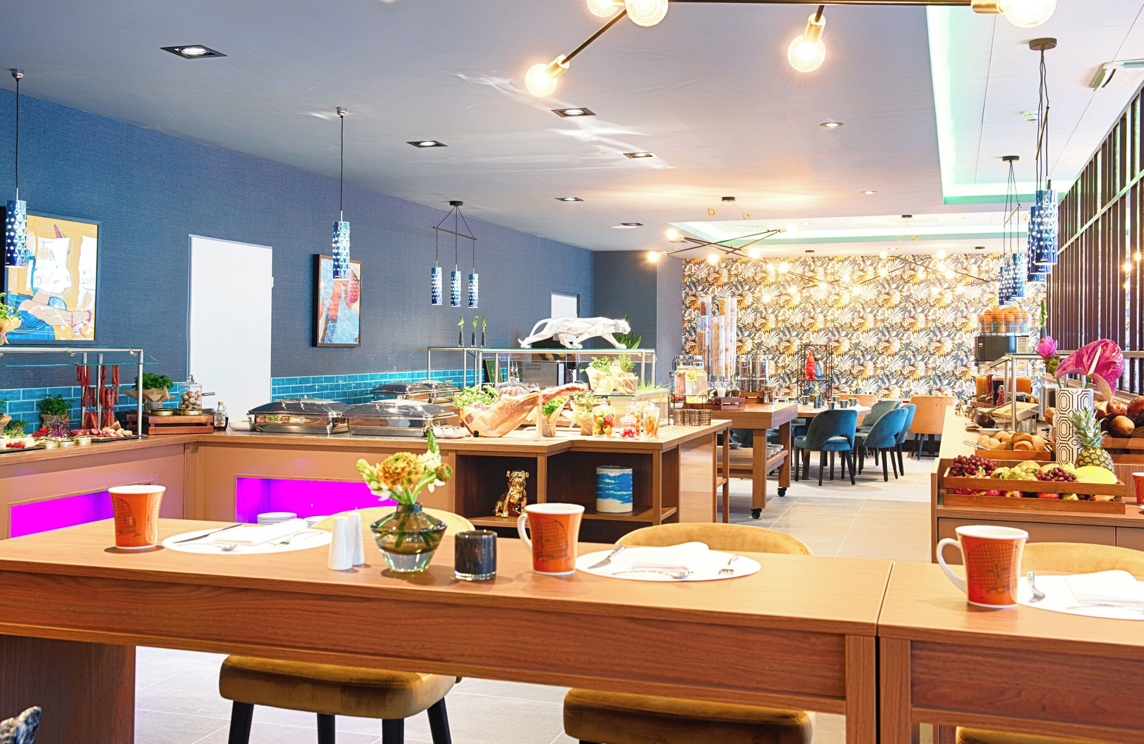 Un restaurante moderno con una barra central, mesas y sillas para comer.