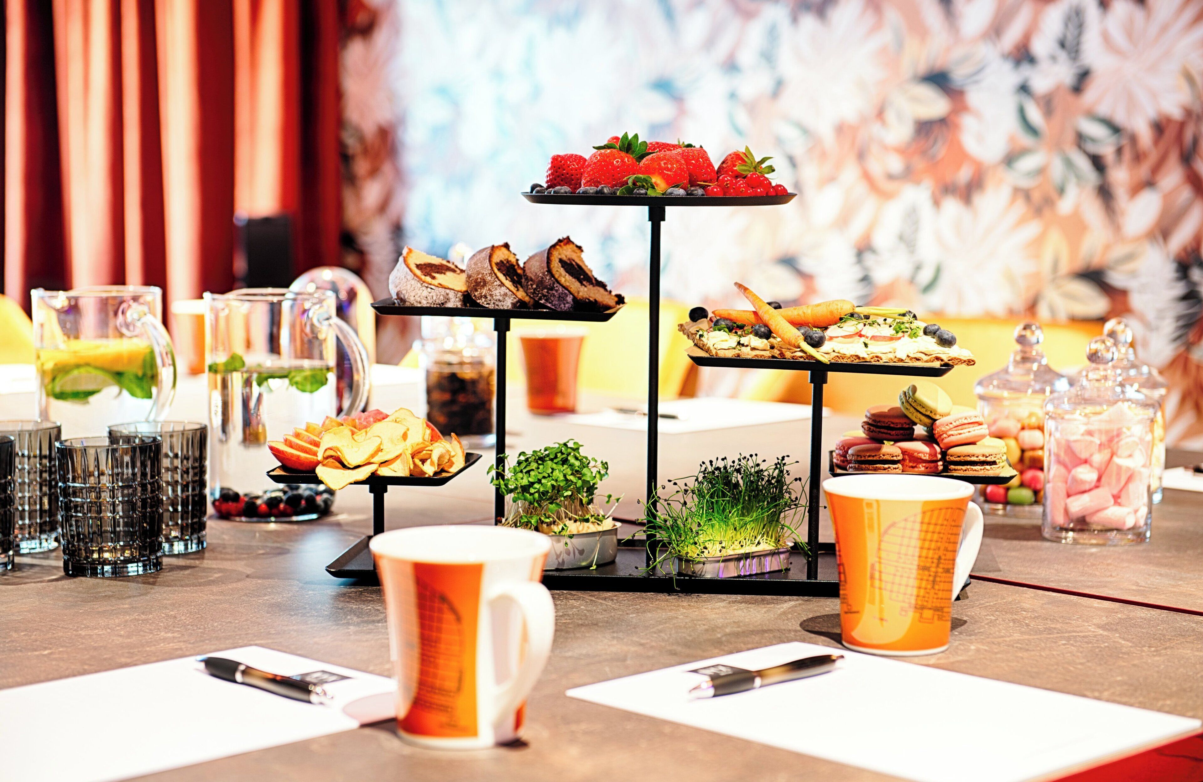 A breakfast buffet with various pastries, fruits, and beverages.