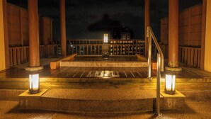 A nighttime view of a traditional Japanese building with a wooden structure, a stone platform, and a railing. - Dantoukan Kikunoya (Otsu)