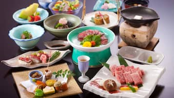 Variedad de platos en una mesa, incluyendo sushi, sashimi y otras especialidades japonesas.