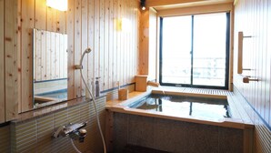 A wooden interior with a hot tub, wooden walls, a window, and a mirror. - Dantoukan Kikunoya (Otsu)