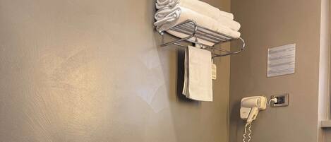 A modern bathroom with a bidet, toilet, and a vanity with a towel rack and hairdryer.