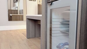 Una cocina moderna con un refrigerador empotrado, una encimera de madera y un espejo sobre el lavamanos.