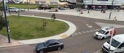 A roundabout with cars, a grassy area, and a building with 'BRITANNIA PIER' signage.