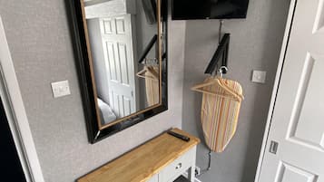 Tabla de planchar con plancha y ropa de cama