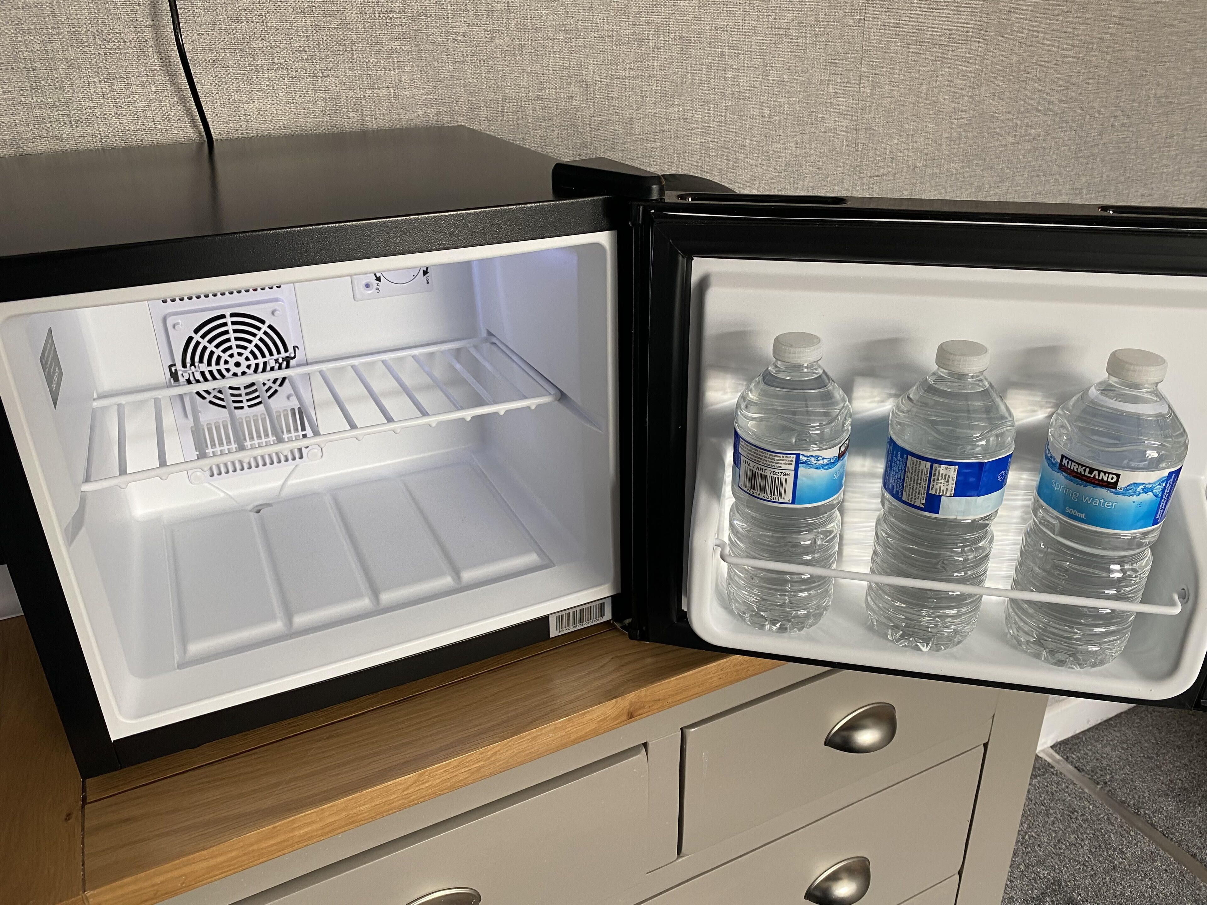 An open refrigerator with a wooden countertop and a metal handle.