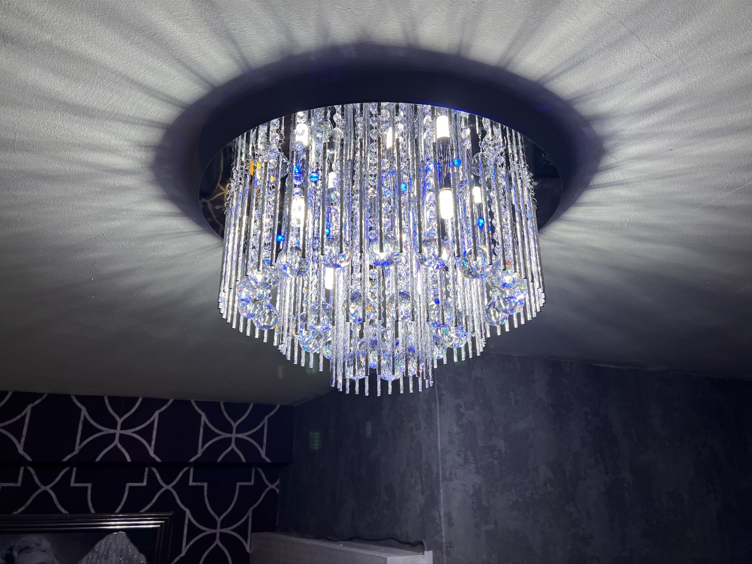 A chandelier with multiple hanging crystal elements and a central light source.