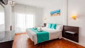 Una habitación de hotel con una cama, un escritorio, una silla, un cuadro y una repisa en la pared.