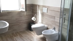 A modern bathroom with a toilet, bidet, and sink. - Affittacamere Ciro's House (Olbia)