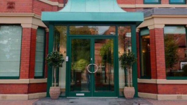 A brick building with a green awning and a glass door entrance. - Newcastle Jesmond Hotel (Newcastle-upon-Tyne)