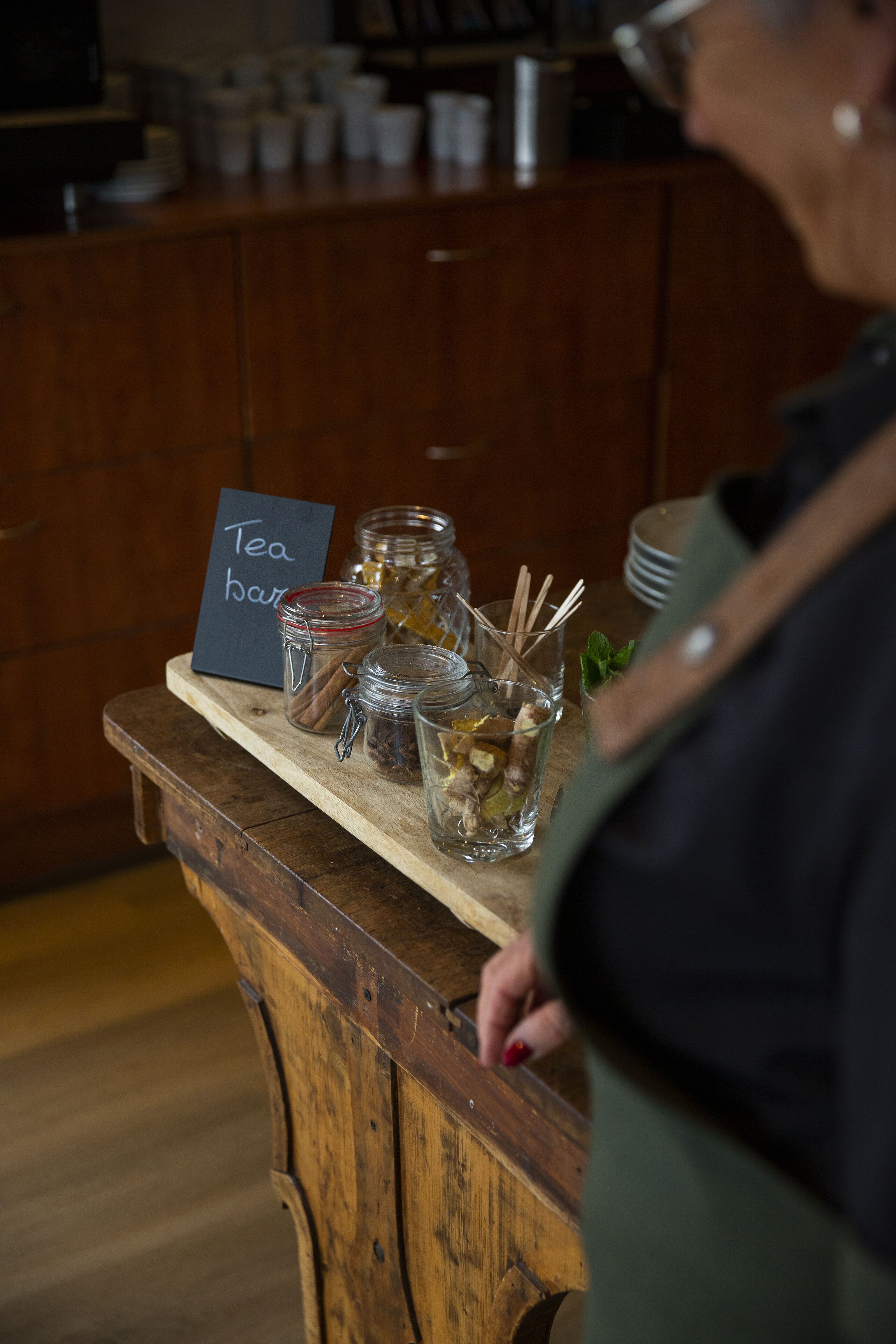 A wooden counter with tea jars and a sign reading "Tea bar".