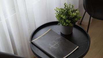 A small round table with a black notebook and a potted plant.