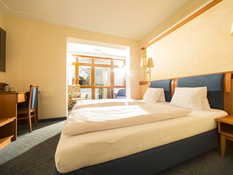 Une chambre d’hôtel avec un grand lit, un bureau et une chaise.