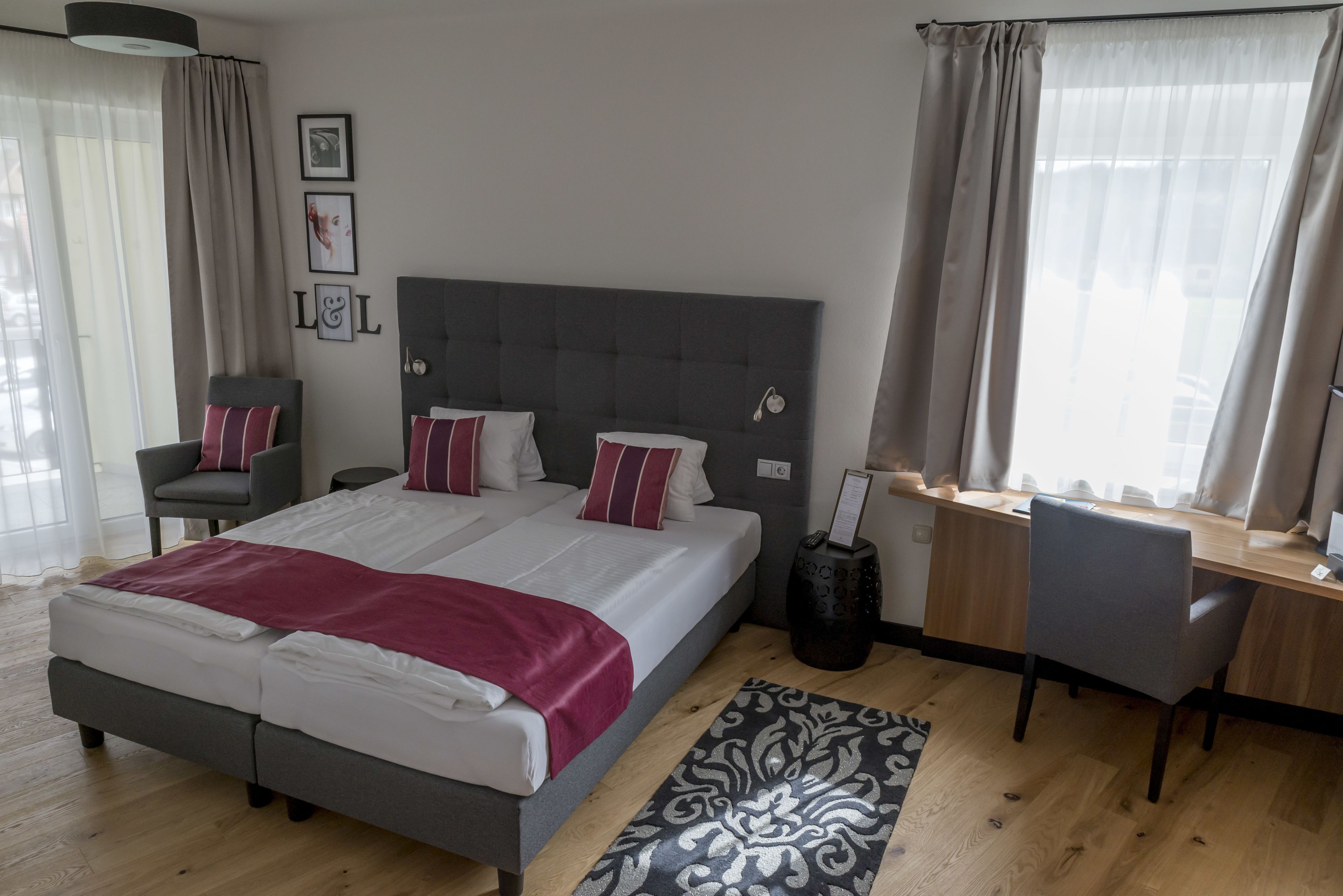 Ein modernes Hotelzimmer mit einem großen Bett, einem Schreibtisch und einem Sessel.