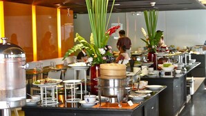 A buffet setup with various food stations, including a large pot and several bowls, in a well-lit indoor setting. - The Heritage Hotels Bangkok (Bangkok)