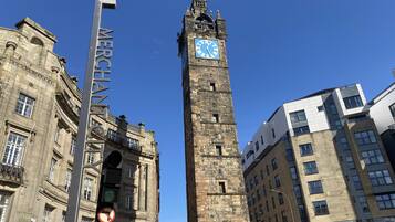 A historic clock tower with a clock face, surrounded by modern buildings.
