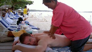 A beachside massage area with lounge chairs and a massage table. - Samui Beach Apartments (Koh Samui)