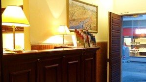 Un mostrador de recepción con un mapa, una lámpara y una puerta de vidrio que da al exterior.