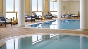 A pool area with lounge chairs and a large window. - Marriott Executive Apartments Riyadh, Convention Center (Riyadh)