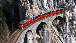 Un tren rojo sobre un puente con múltiples arcos.