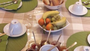 A buffet table with various dishes, including fruits, pastries, and condiments. - La Cognee (Cugnaux)