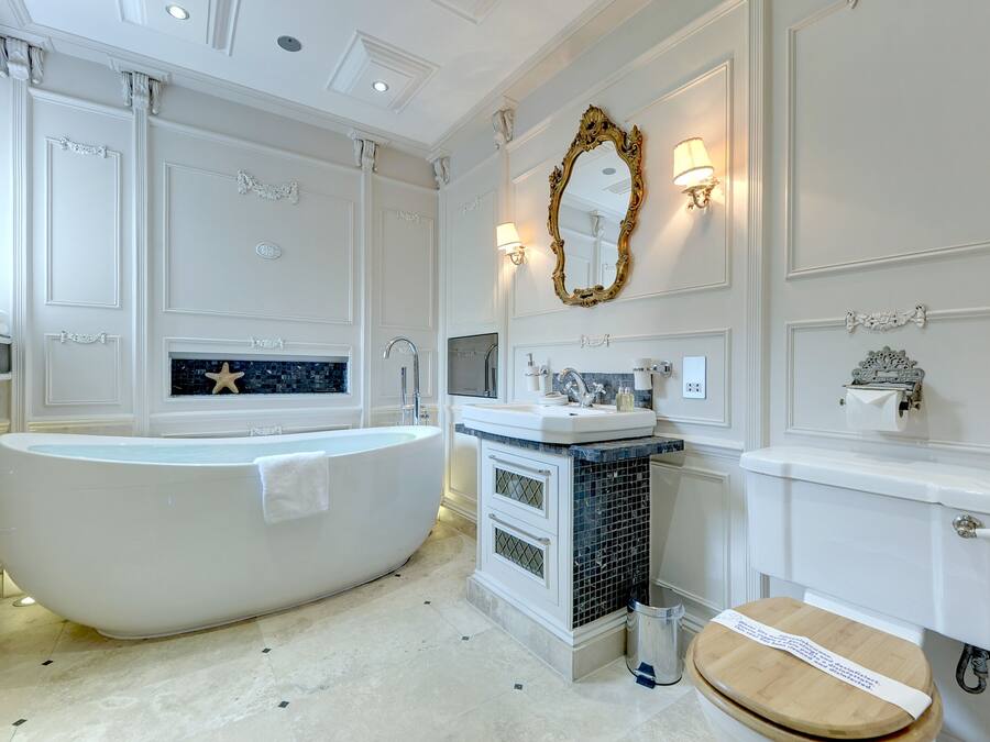 A bathroom with a freestanding bathtub, a sink with a mirror, and a toilet.