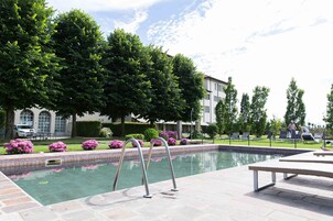 Una piscina al aire libre, tumbonas