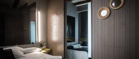 Un dormitorio moderno con una cama grande, mesitas de noche y un espejo.