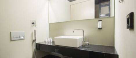 A bathroom with a white toilet, a sink with a mirror above it, and a towel rack.
