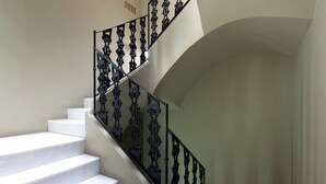 A staircase with white steps and ornate black railings. - Cosy Rooms Bolsería (Valencia)