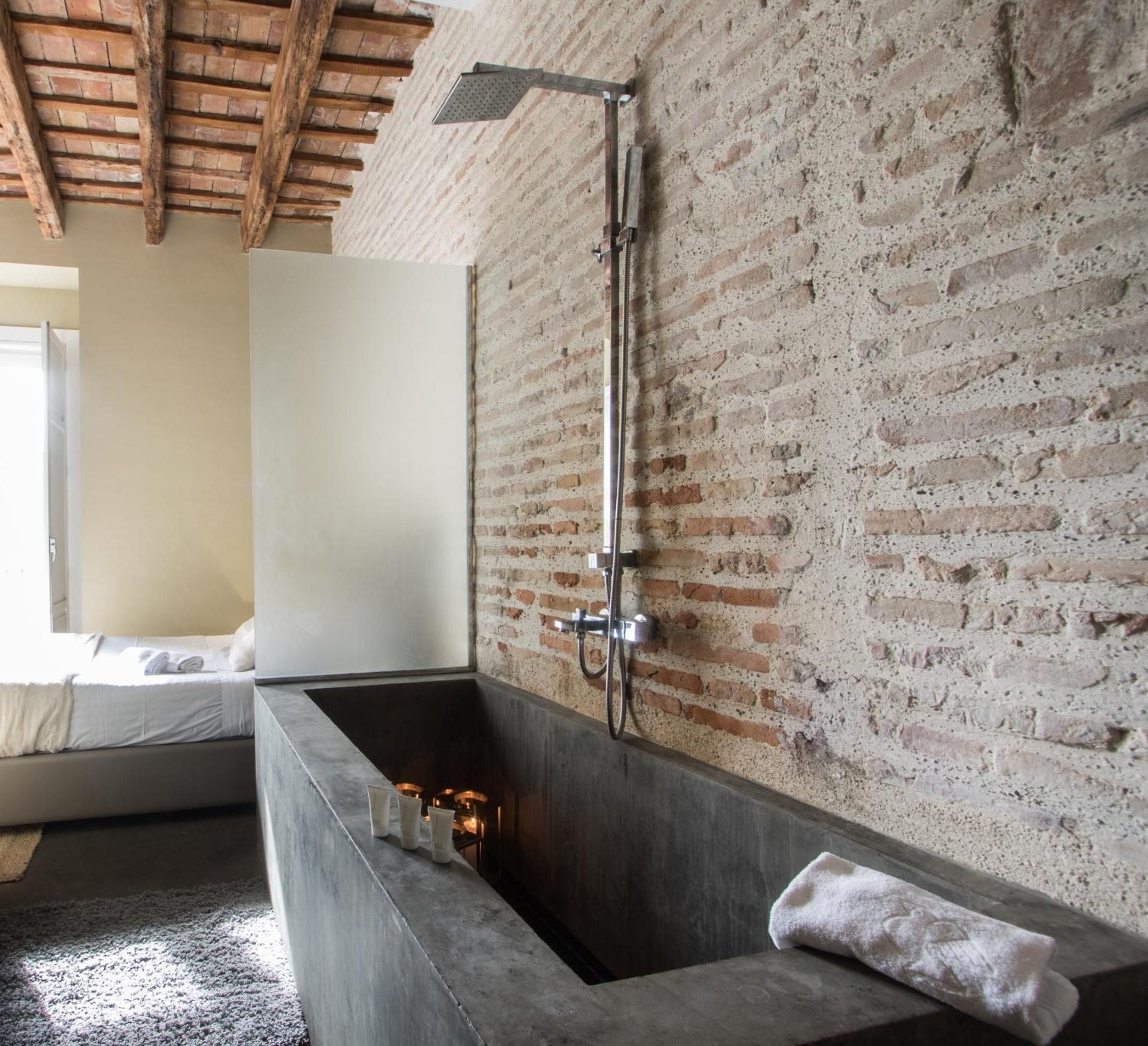 A modern bathroom with a large bathtub, a shower, and a minimalist design.