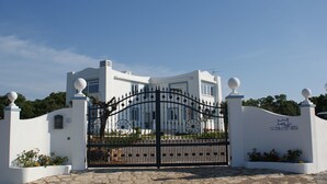 A white building with a black wrought iron gate and a sign reading "casamediterranea". - Casamediterranea (Itri)